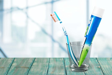 toothbrush and toothpaste in glass holder